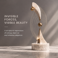 HOMZURE gold arc sculpture styled on a console beside stacked books and a bowl
