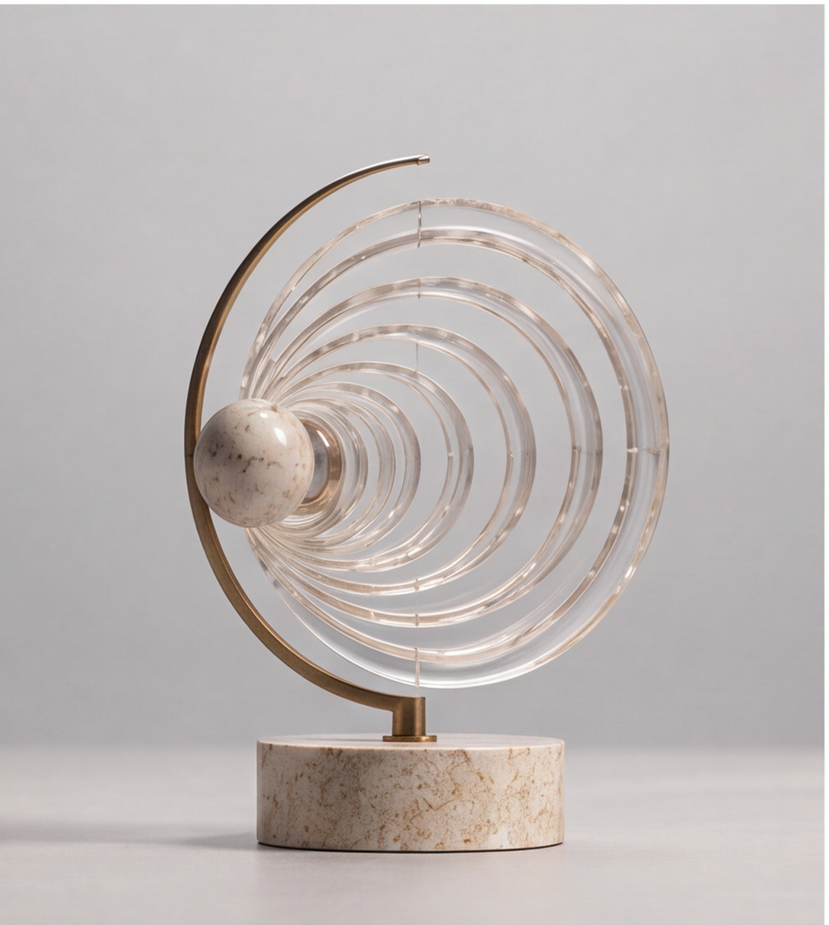 Front view of HOMZURE decorative sculpture with clear rings radiating from a speckled sphere