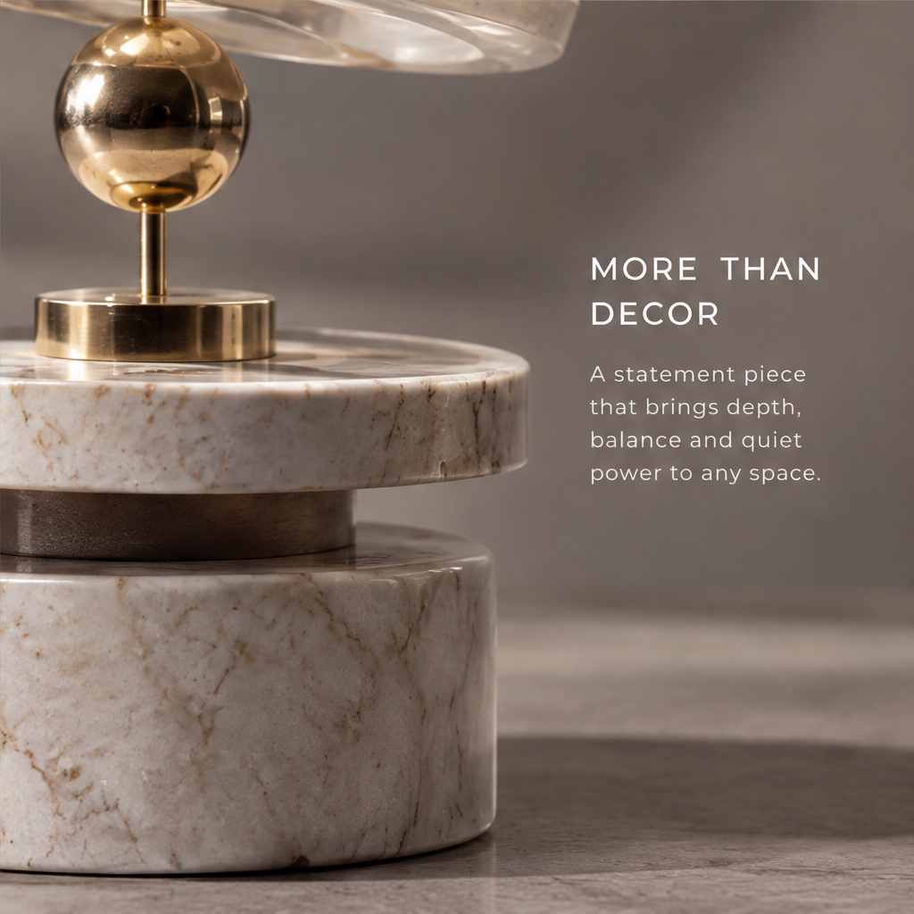 HOMZURE stacked orbit sculpture with clear circular layers and gold-tone spheres above a pale veined cylindrical base on a plain backdrop