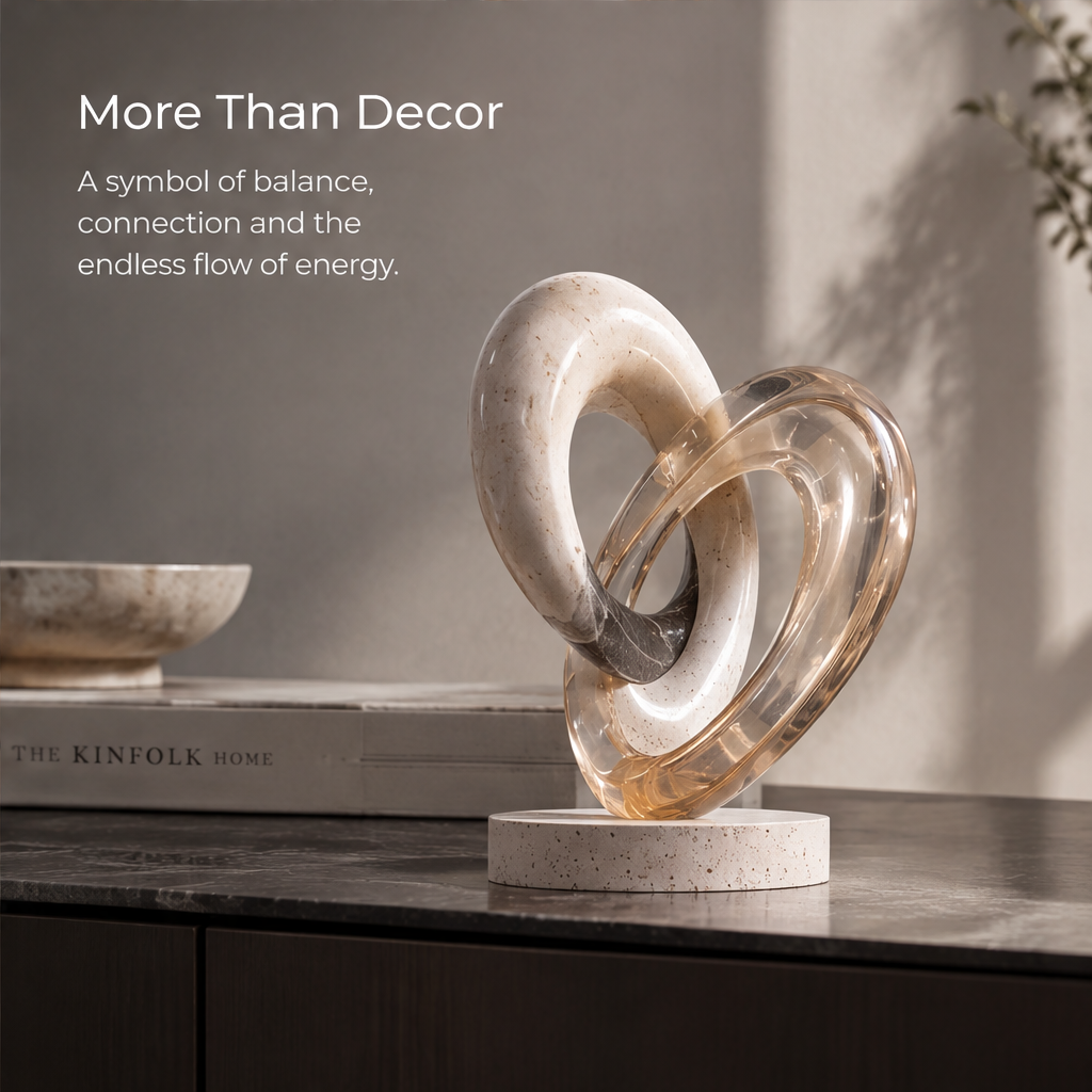 HOMZURE interlocking loop sculpture with a pale speckled ring and translucent amber-toned ring on a light round base against a plain background