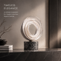 HOMZURE layered ring sculpture styled on a dark console with books and a vase