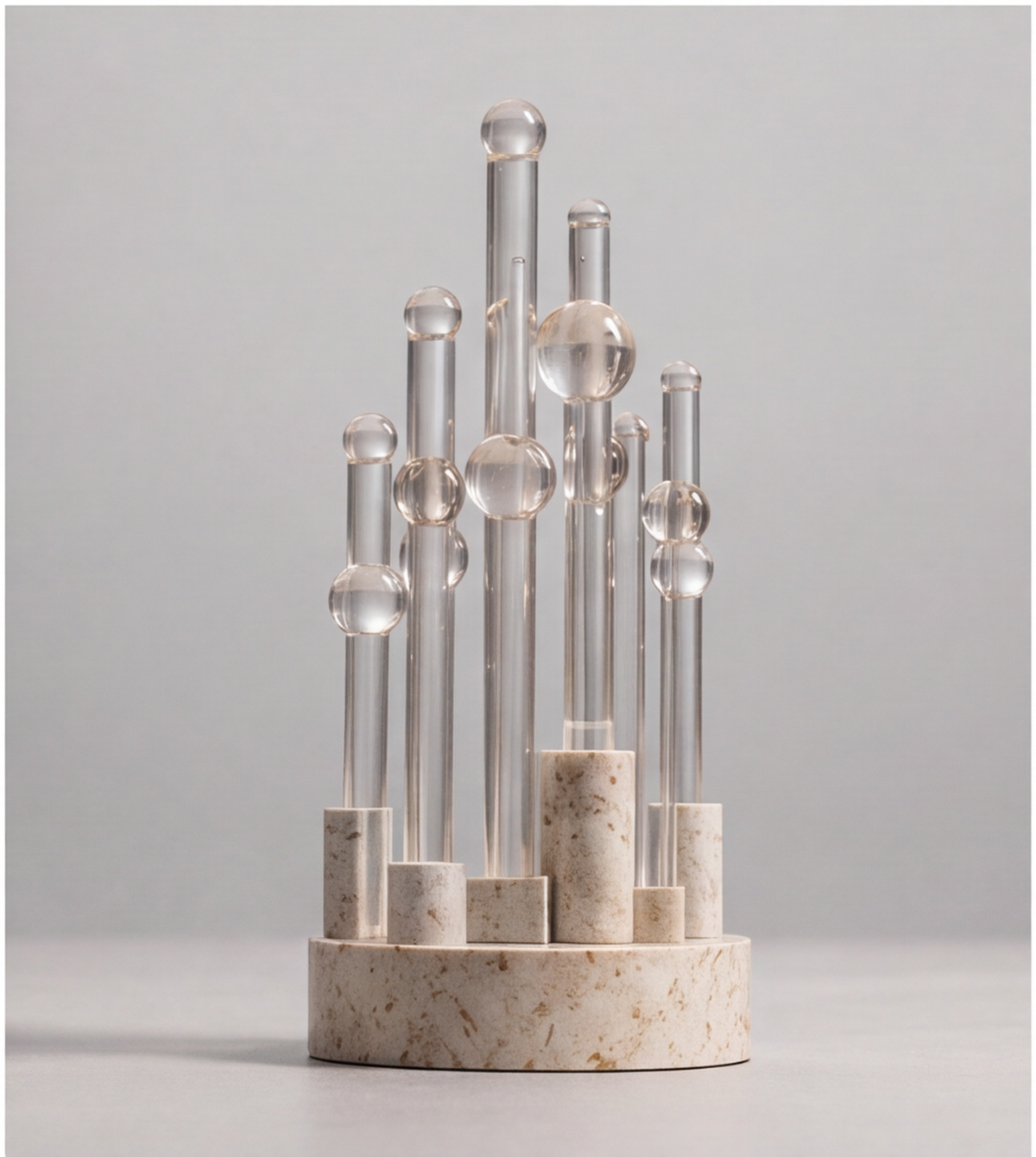 HOMZURE clear sphere and column sculpture in angled light on a tabletop